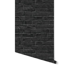 May include: Black brick wallpaper with a textured surface. The wallpaper is rolled up and the edge is visible.