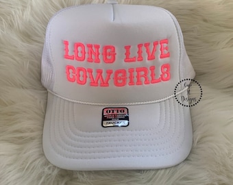 Op de afbeelding: Witte trucker-pet met een roze geborduurd ontwerp dat "Long Live Cowgirls" zegt.