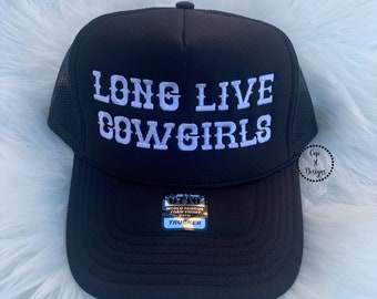 Op de afbeelding: Zwarte truckercap met witte geborduurde tekst die "Long Live Cowgirls" luidt.