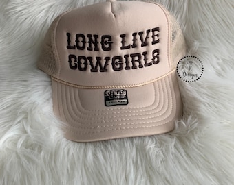 Op de afbeelding: Een beige trucker-pet met een bruin geborduurd ontwerp met de tekst "Long Live Cowgirls".