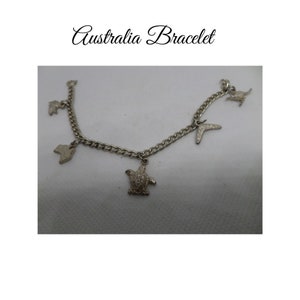 Bracelet de charme Australiana en acier inoxydable. Les charmes incluent crocodile, carte de l’Australie, tortue de mer, boomerang, kangourou