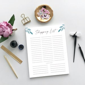 Puede incluir: Un bloc de notas imprimible de lista de la compra blanco con un dise&ntilde;o floral de acuarela azul y verde y el texto "Shopping List" en la parte superior. El bloc de notas tiene una l&iacute;nea para escribir art&iacute;culos y una secci&oacute;n para marcas.