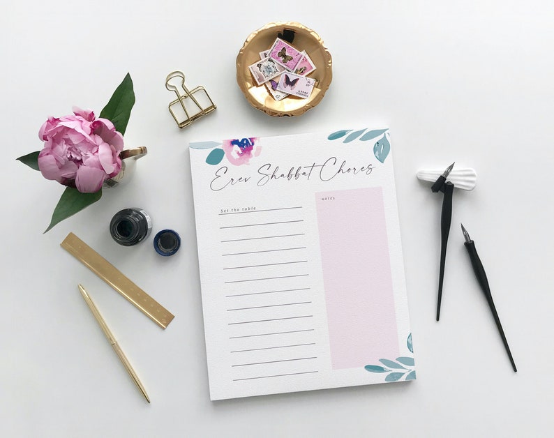 Puede incluir: Un bloc de notas blanco con un dise&ntilde;o floral y el texto "Erev Shabbat Chores" impreso en la parte delantera. El bloc de notas tiene una secci&oacute;n rosa con el encabezado "Notes" y una secci&oacute;n blanca con el encabezado "Set the Table".