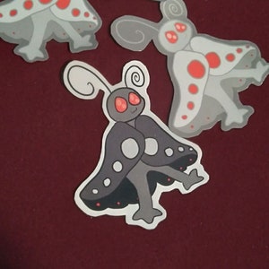 May include: Three gray and white butterfly stickers with red spots. The stickers have a handwritten message that says "Stay safe, stay kind, stay weird."