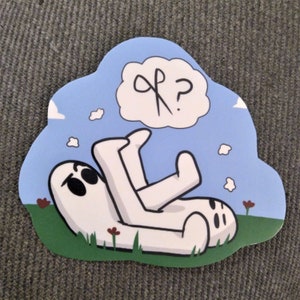 May include: A white cartoon character with large eyes lies on its back in a field of green grass with red flowers. The character has a thought bubble above its head with a pair of scissors and a question mark.
