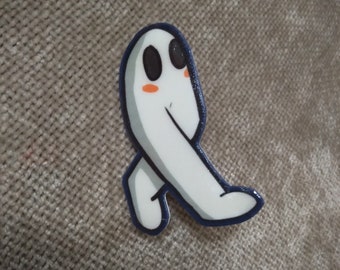 May include: A white ghost with black eyes and orange cheeks is walking. The ghost is a cartoon-style illustration and is a pin.