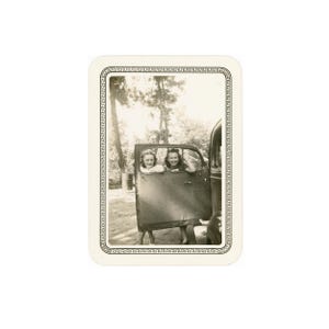 May include: Black and white photograph of two women in a vintage car. The car door is open, and the women are smiling. The photograph has a decorative border.
