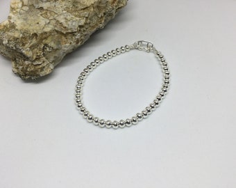 Könnte beinhalten: Ein silbernes Armband mit Perlen und einem Verschluss.