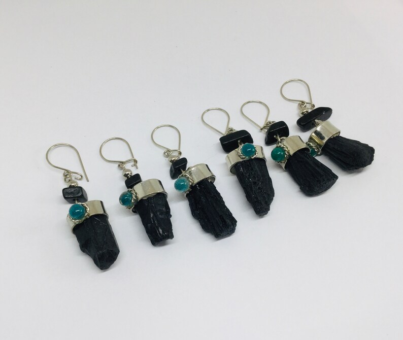 May include: Six pairs of black tourmaline earrings with silver hoops and green gemstone accents.