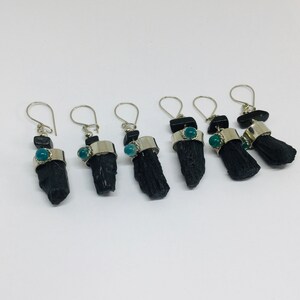 May include: Five pairs of black tourmaline earrings with silver accents and green gemstone accents.