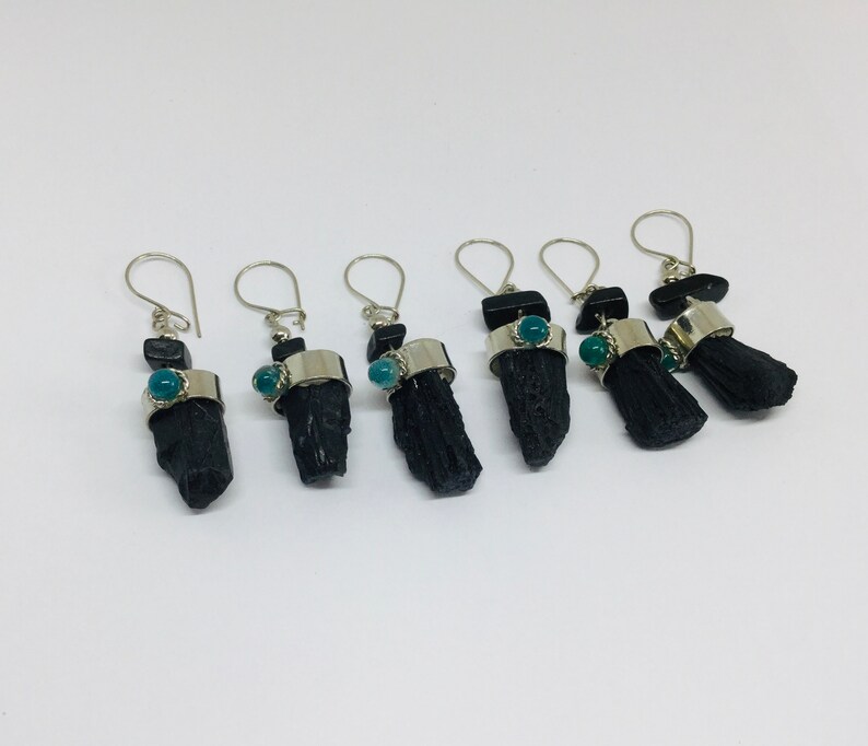 May include: Five pairs of black tourmaline earrings with silver accents and green gemstone accents.
