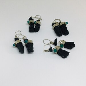 May include: Three pairs of black tourmaline earrings with green gemstone accents. The earrings are made with silver and feature black tourmaline crystals and green gemstones.