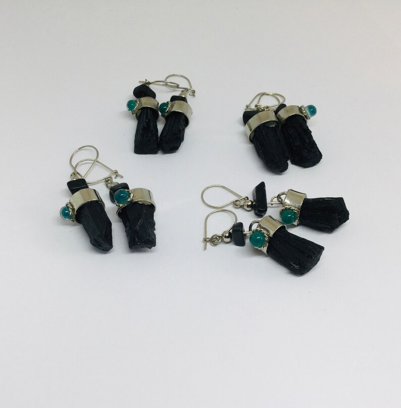 May include: Three pairs of black tourmaline earrings with green gemstone accents. The earrings are made with silver and feature black tourmaline crystals and green gemstones.