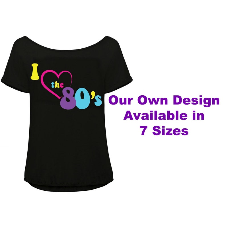 K&ouml;nnte beinhalten: Schwarzes Off-Shoulder-T-Shirt mit dem Text "I love the 80's" in Gelb, Rosa, Lila und Blau. Das Shirt hat auch den Text "Our Own Design Available in 7 Sizes".