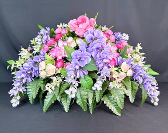 Flores conmemorativas de glicinia lavanda, silla de montar para lápida, homenaje de condolencia, arreglo funerario en cementerio.