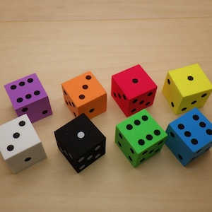 May include: Eight foam dice in different colors: purple, orange, red, yellow, black, green, blue, and white. Each die has black dots on the sides.