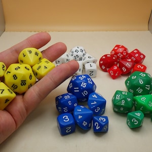 May include: A collection of colorful dice in various shapes and sizes. The dice are yellow, red, blue, and green. Some of the dice have black numbers, while others have white numbers.