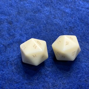 May include: Two ivory-colored, twenty-sided dice with Roman numerals. The dice are displayed on a blue textured surface. Each die has a different face visible, showcasing the numerals.