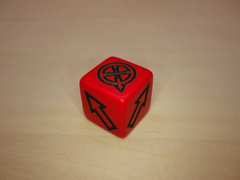 Puede incluir: Un dado rojo de seis caras con marcas negras. El dado tiene un s&iacute;mbolo de un c&iacute;rculo con cuatro flechas apuntando hacia afuera en un lado y una flecha apuntando hacia arriba en otro lado.