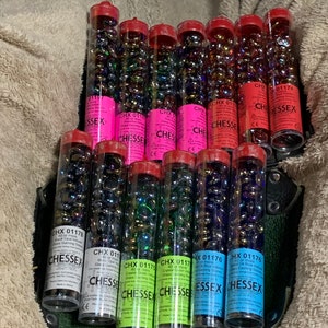 May include: Multiple clear plastic tubes filled with iridescent glass marbles. The tubes have labels that read "CHX 01176" and "CHESSEY".