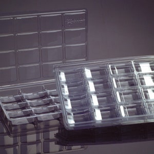 May include: Two clear plastic trays with multiple compartments. The trays are stacked on top of each other.