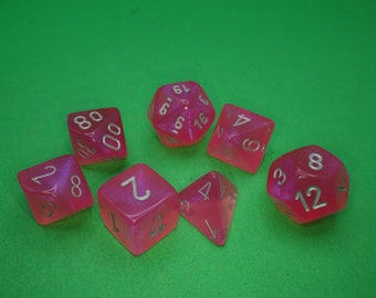 May include: A set of seven pink dice with silver numbers. The dice are in various shapes and sizes, including a d4, d6, d8, d10, d12, and d20.
