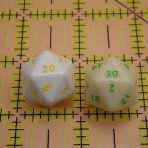 May include: A white ceramic mug with a black handle and the text "But First, Coffee" in a handwritten style. The mug is on a white surface. The mug is 4 inches tall.