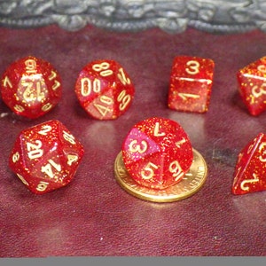 May include: A set of seven red dice with gold glitter and gold numbers. The dice are a d4, d6, d8, d10, d12, d20, and a d%.