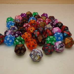 May include: A collection of colorful, multi-sided dice with white numbers. The dice are made of clear plastic and have a variety of finishes, including glitter and iridescent.