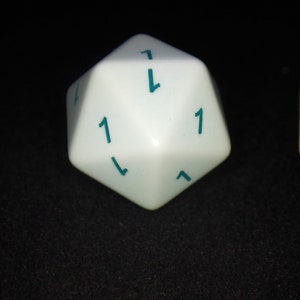 May include: A white twenty-sided die featuring teal-colored numbers printed on each triangular face. The die displays the number one prominently on the top face, with other faces showing additional numbers in the same teal ink color.