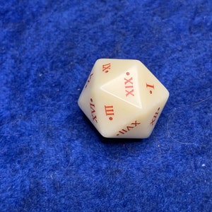 May include: Ivory-colored twenty-sided die with red Roman numerals. The die is a dodecahedron, a twelve-sided shape. The die is on a blue surface.