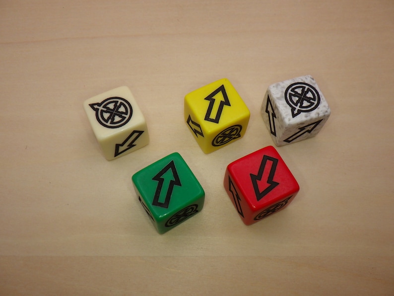 Puede incluir: Cinco dados con caras de diferentes colores. Los dados son blanco, amarillo, rojo, verde y gris. Cada dado tiene un s&iacute;mbolo diferente en cada cara. Los s&iacute;mbolos son un c&iacute;rculo con una l&iacute;nea que lo atraviesa, una flecha apuntando hacia arriba, una flecha apuntando hacia abajo y un c&iacute;rculo con una l&iacute;nea que lo atraviesa.