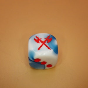 May include: A white and blue dice with red crossed axes on one side and red dots on the other sides.