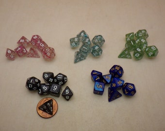 May include: A set of ten polyhedral dice in five different colors: pink, blue, green, black, and blue. The dice are made of clear plastic with glitter embedded in the plastic. The dice are numbered with white or gold numbers.
