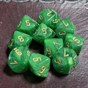 May include: A set of eight green dice with gold numbers. The dice have a marbled effect and are perfect for tabletop games.