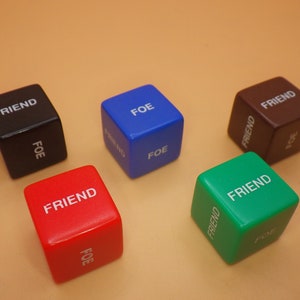 May include: Five dice with the words "Friend" and "Foe" on each side. The dice are black, blue, red, green, and brown.
