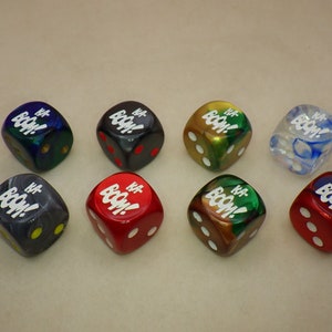May include: Eight dice with the words "KA-BOOM!" printed on each side. The dice are in various colors, including red, green, blue, black, and clear.