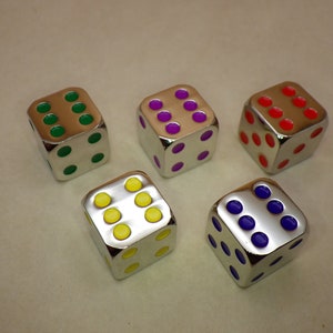 May include: Five silver dice with different colored dots. The dice are green, purple, red, yellow, and blue.