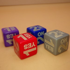 May include: Four dice with the numbers 1 and 2 on each side. The dice are purple, blue, red, and gray. The word "YES" is printed on each die.