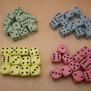 May include: A collection of dice in three colors: green, yellow, and pink. Each die has black dots on its faces.