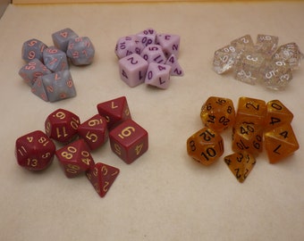 May include: A set of 10 dice in various colors and materials, including clear, purple, red, and gold. The dice are numbered with black and gold ink.