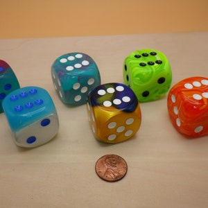 May include: Six colorful dice with white dots. The dice are made of clear plastic with swirls of color. The colors are blue, green, yellow, orange, and red.