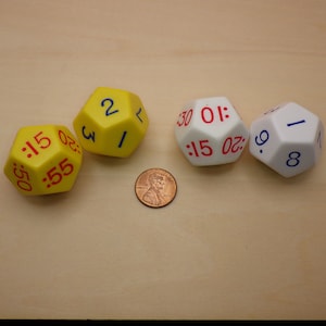 May include: Four dice, two yellow and two white, with red numbers on each side. The dice are numbered 1, 2, 3, 5, 9, 15, 20, 30, 50, and 55.