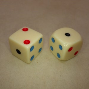 May include: Two white dice with black and red dots. One die has three blue dots and one red dot. The other die has one black dot and two red dots.