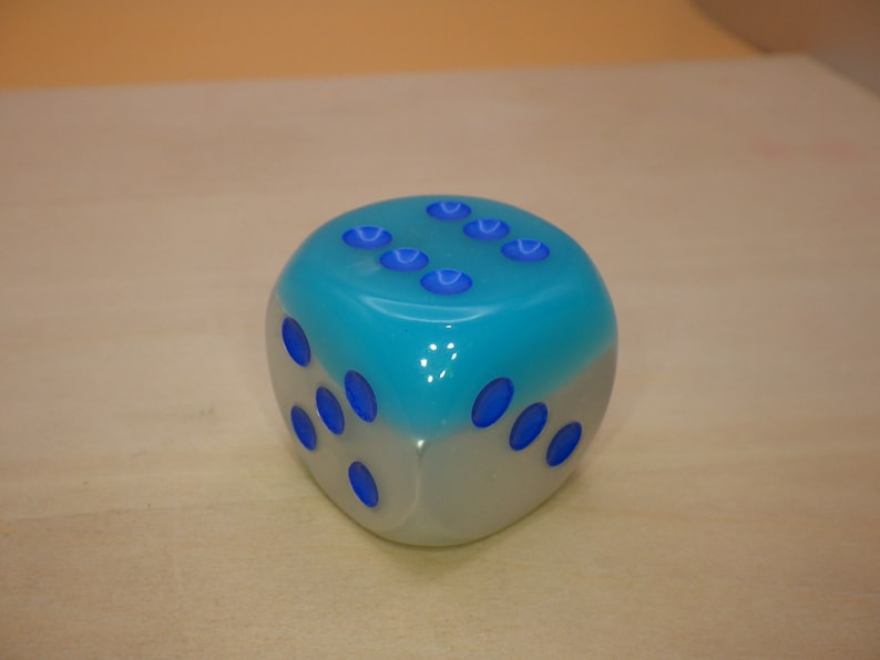 May include: A blue and white dice with blue dots on each side.