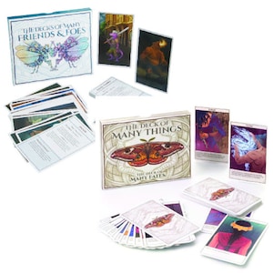 May include: Three boxed sets of playing cards with illustrated imagery. The first box is titled "The Decks of Many Friends & Foes" and features a pair of colorful butterflies. The second box is titled "The Deck of Many Things" and features a large, colorful moth. The third box is titled "The Deck of Many Fates" and features a colorful moth.