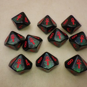 May include: Ten black dice with green and red accents. Each die has an ankh symbol and numbers 4 and 8 on the faces.
