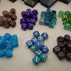 May include: A collection of 10 different colored dice with white dots. The dice are made of clear plastic and have a variety of colors, including blue, green, purple, and orange.