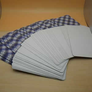 May include: A deck of playing cards with a blue and white plaid pattern on the back. The cards are fanned out to show the blank white fronts.