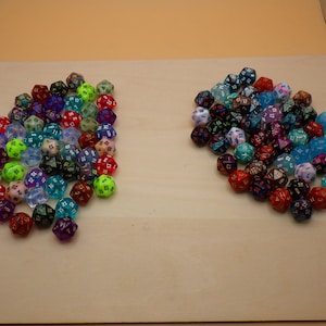 May include: A large group of iridescent dice in various colors, including red, blue, green, and purple. The dice are scattered on a light brown surface.